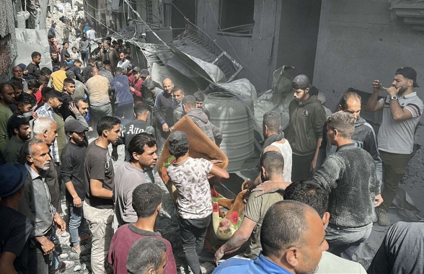 طفل غزي مصاب يلوح بيده بعد أن قذفه القصف الإسرائيلي إلى المبنى المجاور- (شاهد)